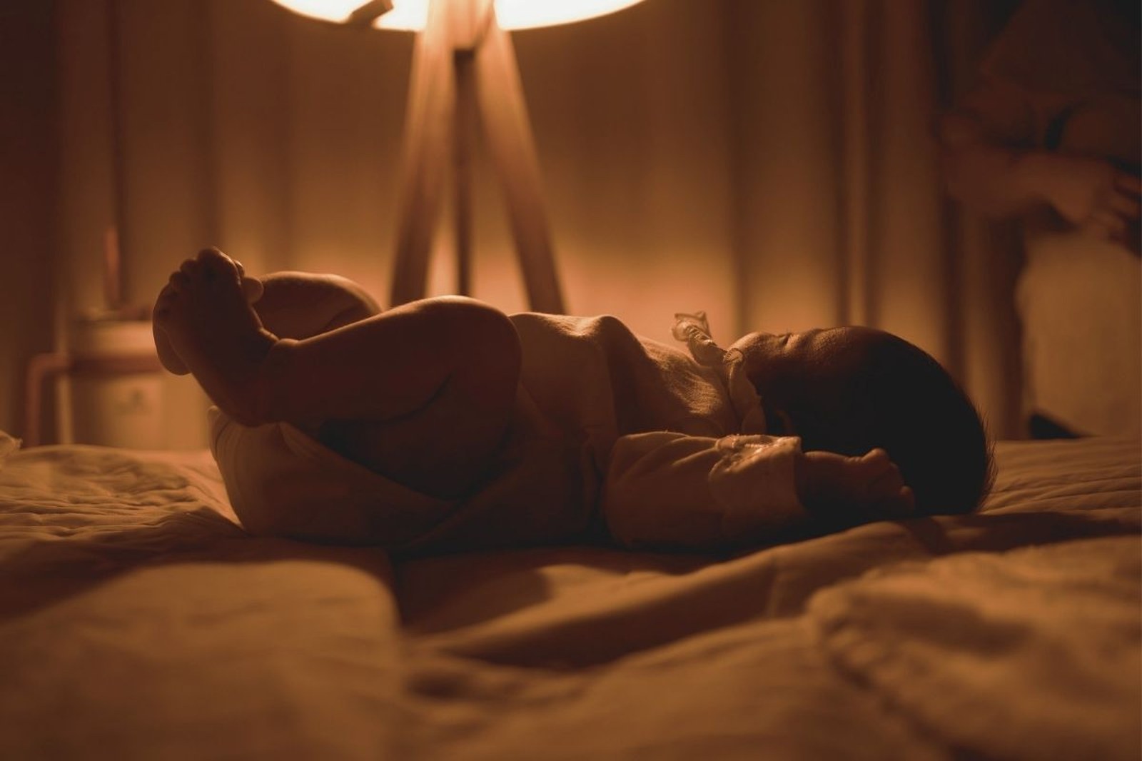 Parent holding baby in dark room, just the two of them, intimate