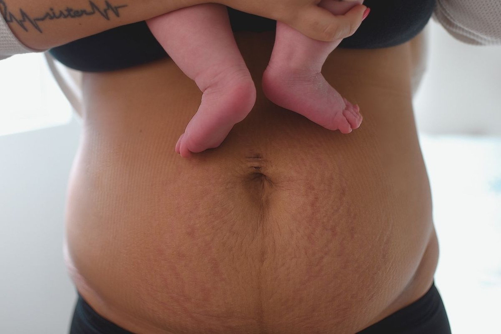 Newborn curled on parent's chest, skin to skin contact, fourth trimester